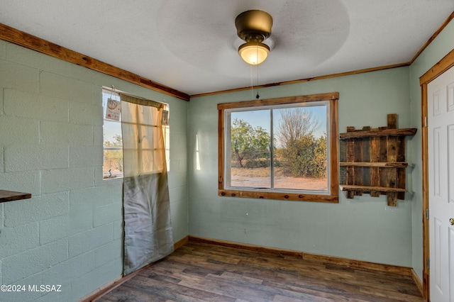 empty room with ceiling fan, dark hardwood / wood-style flooring, and crown molding