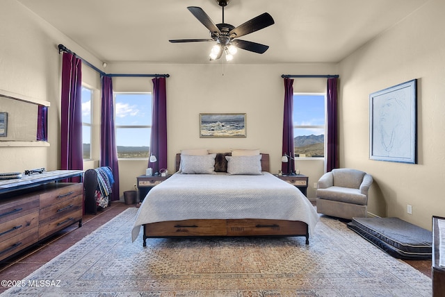 bedroom featuring multiple windows, ceiling fan, and dark tile patterned floors