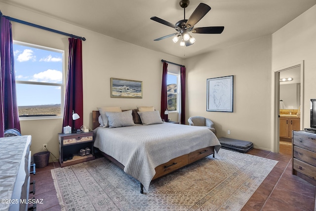 bedroom featuring ensuite bath, ceiling fan, and dark tile patterned floors