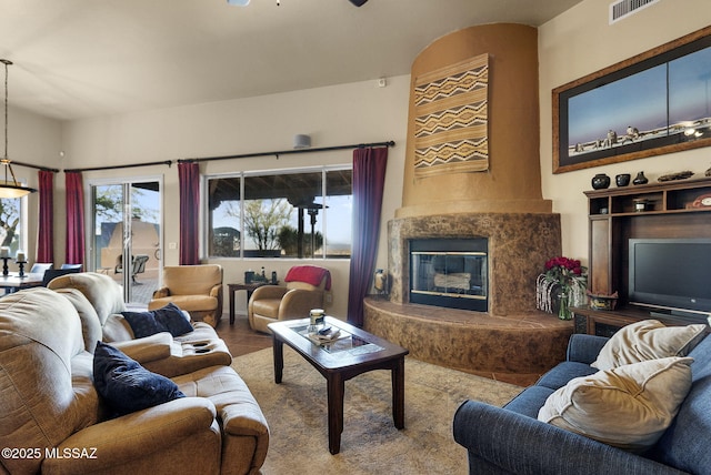 living room featuring tile patterned flooring, ceiling fan, and a high end fireplace