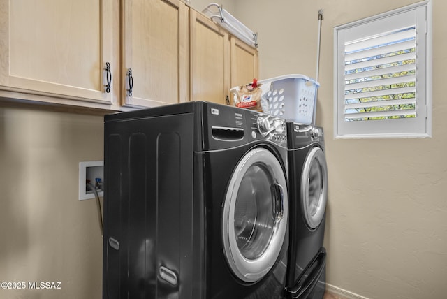 clothes washing area with cabinets and washing machine and dryer