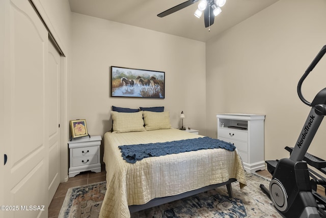 tiled bedroom featuring ceiling fan and a closet