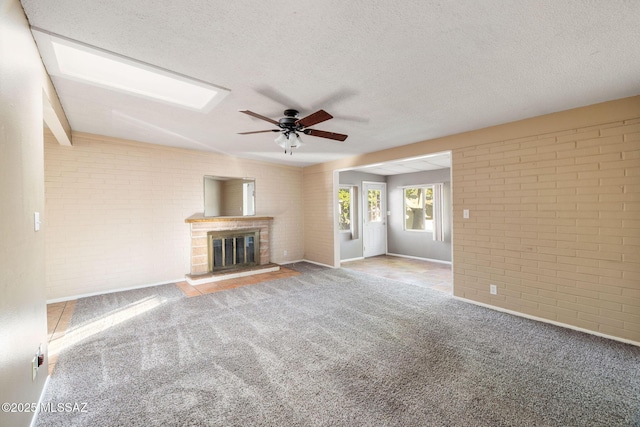 unfurnished living room with brick wall, carpet flooring, and a textured ceiling