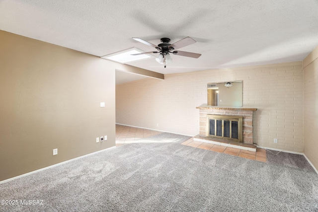 unfurnished living room with ceiling fan, brick wall, light carpet, and a textured ceiling