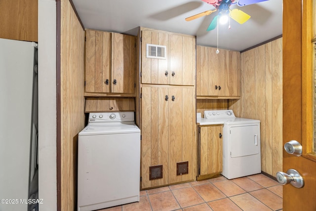 laundry area featuring ceiling fan, cabinets, and light tile patterned floors