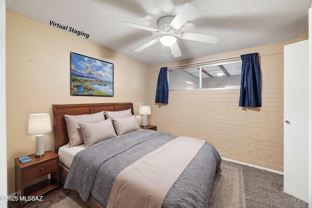 bedroom with brick wall, dark carpet, a textured ceiling, and ceiling fan