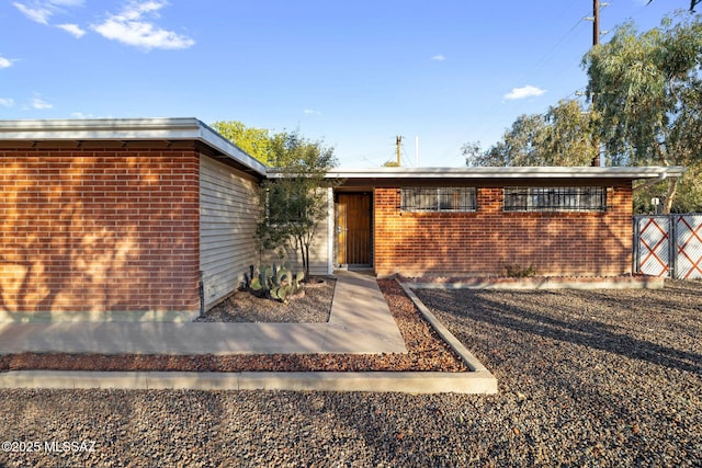 view of front of house with fence and brick siding