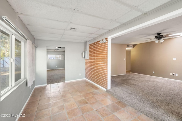 empty room featuring light carpet, a drop ceiling, and ceiling fan