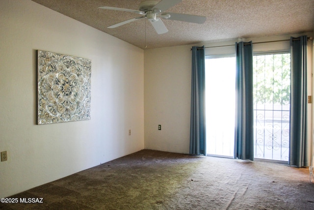 carpeted spare room featuring a textured ceiling and ceiling fan