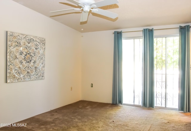 carpeted empty room with a ceiling fan