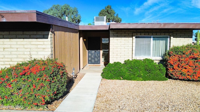 entrance to property featuring brick siding