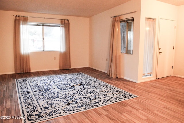 empty room with baseboards and wood finished floors