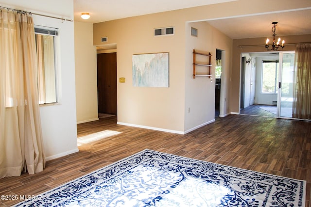 entrance foyer with a notable chandelier, baseboards, visible vents, and wood tiled floor