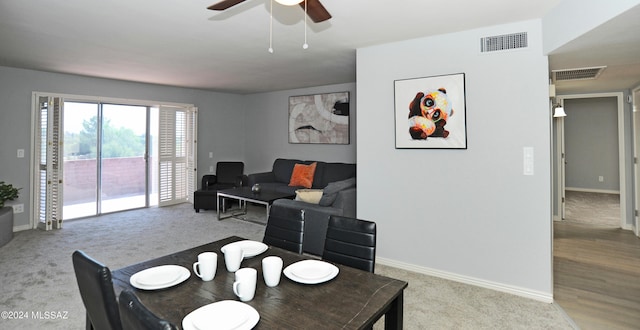 carpeted dining room featuring ceiling fan