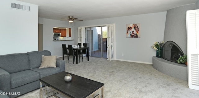 carpeted living room with ceiling fan