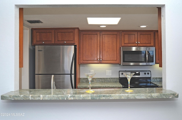 kitchen featuring appliances with stainless steel finishes and light stone counters