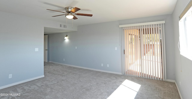 carpeted spare room featuring ceiling fan