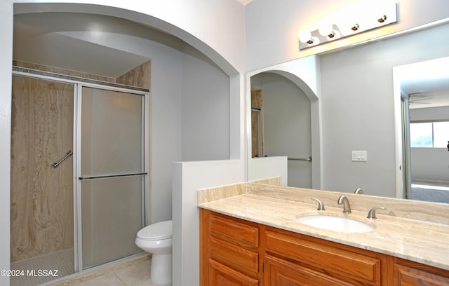 bathroom featuring toilet, a shower with door, vanity, and tile patterned floors