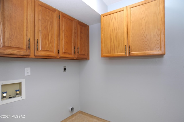 clothes washing area featuring electric dryer hookup, washer hookup, and cabinets