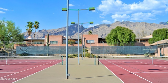 view of tennis court with basketball court and a mountain view