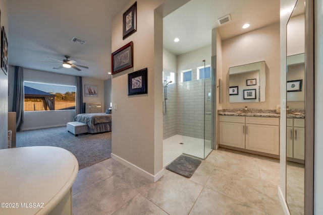 ensuite bathroom featuring a shower stall, visible vents, ceiling fan, and connected bathroom