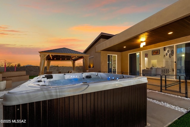view of patio / terrace with a fenced backyard, a gazebo, and a hot tub