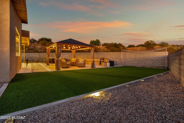 yard at dusk featuring a gazebo, a patio area, and an outdoor hangout area