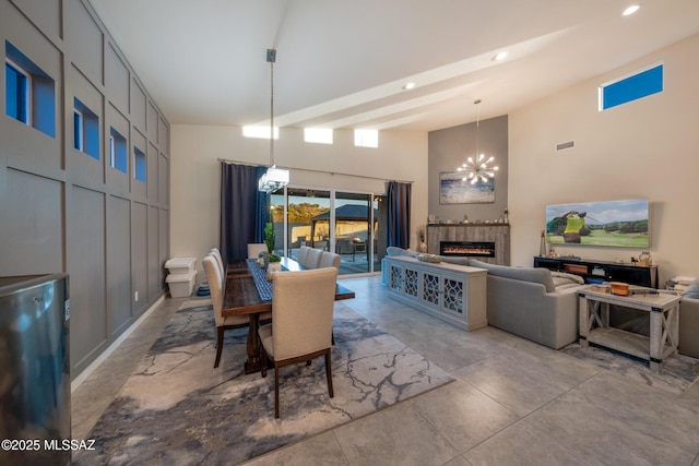 dining area with recessed lighting, a high ceiling, an inviting chandelier, visible vents, and a tiled fireplace