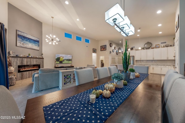 dining room with recessed lighting, a fireplace, and a notable chandelier
