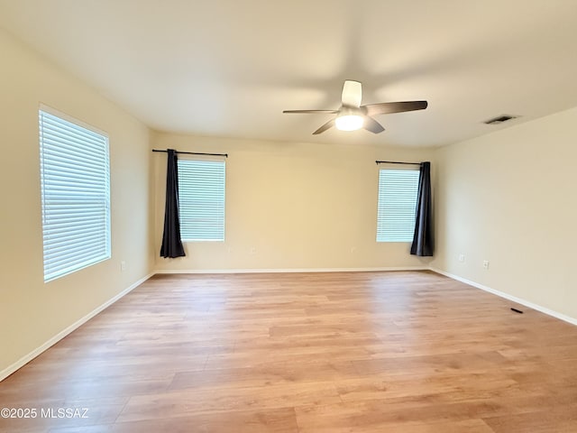 empty room with ceiling fan and light hardwood / wood-style flooring