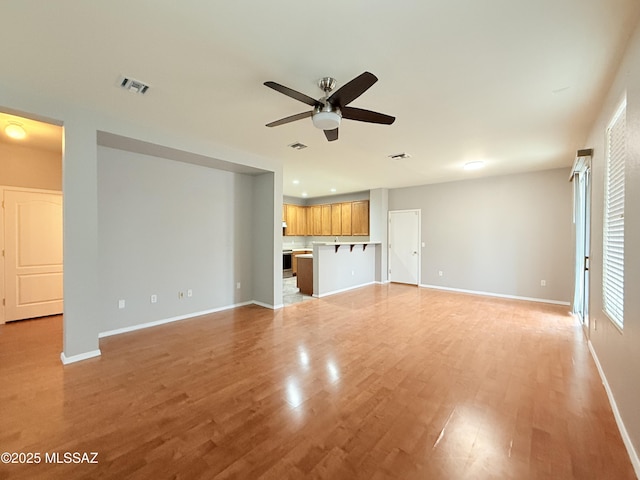 unfurnished living room featuring light hardwood / wood-style floors and ceiling fan