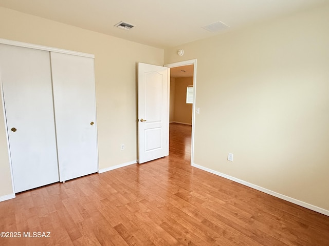 unfurnished bedroom with light hardwood / wood-style flooring and a closet