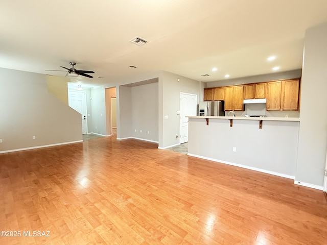 unfurnished living room with ceiling fan and light hardwood / wood-style flooring