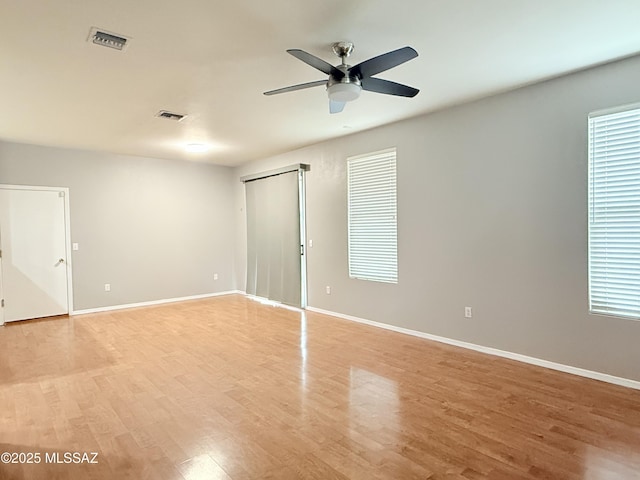 empty room with ceiling fan and light hardwood / wood-style floors