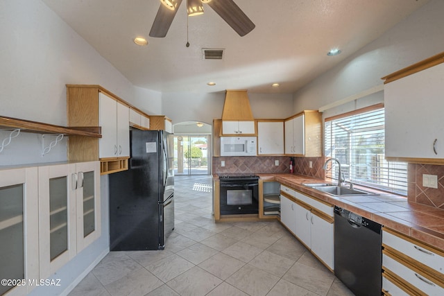 kitchen featuring white cabinets, a sink, and black appliances