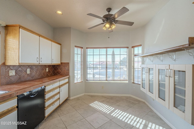 kitchen with dishwasher, decorative backsplash, tile counters, and white cabinets