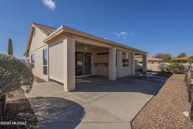 back of property featuring ceiling fan, a patio, a tile roof, fence, and stucco siding