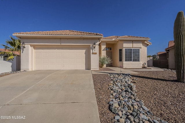 view of front of house featuring concrete driveway, an attached garage, a tile roof, and stucco siding