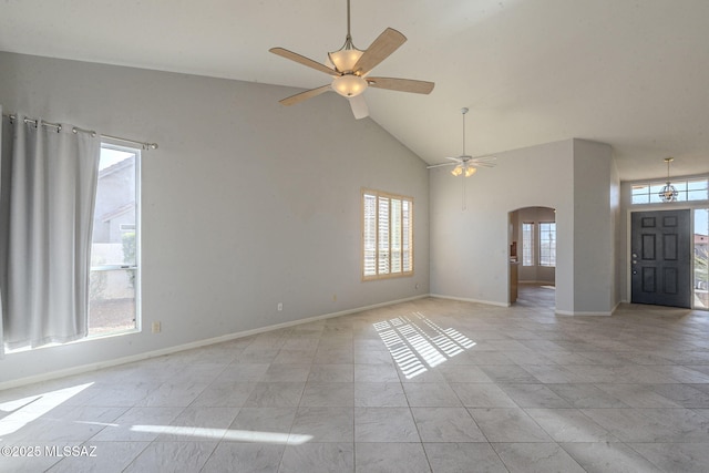 interior space with high vaulted ceiling, ceiling fan, arched walkways, and baseboards