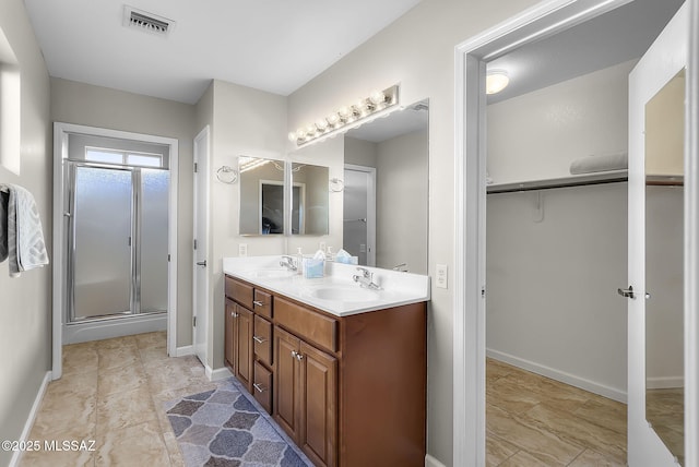 bathroom with a shower with door and vanity