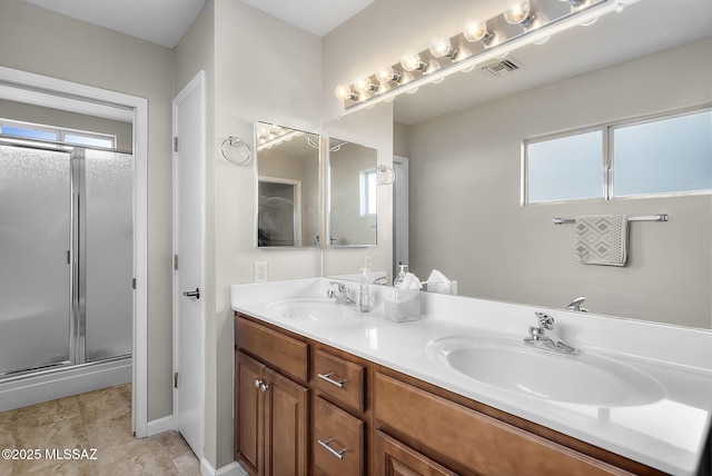 bathroom featuring plenty of natural light, a shower with shower door, and vanity