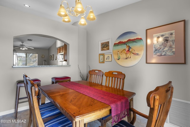 dining space with ceiling fan with notable chandelier and lofted ceiling