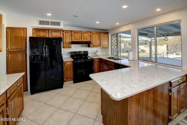 kitchen featuring vaulted ceiling, black appliances, decorative backsplash, a kitchen island, and sink