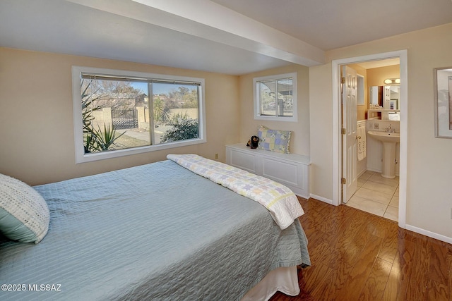 bedroom featuring sink, wood-type flooring, and ensuite bath