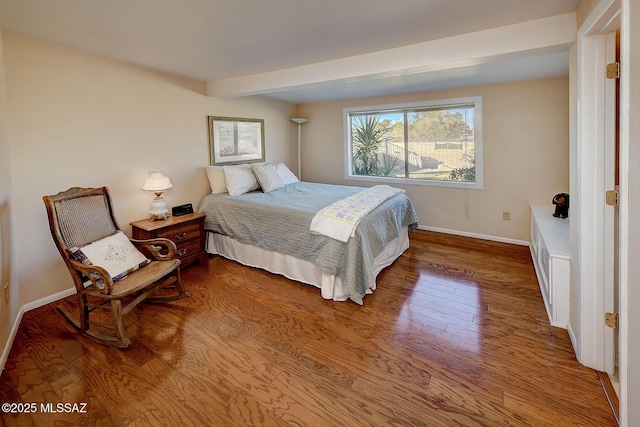 bedroom with wood-type flooring and beam ceiling