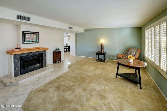 living area with a tile fireplace and light tile patterned floors