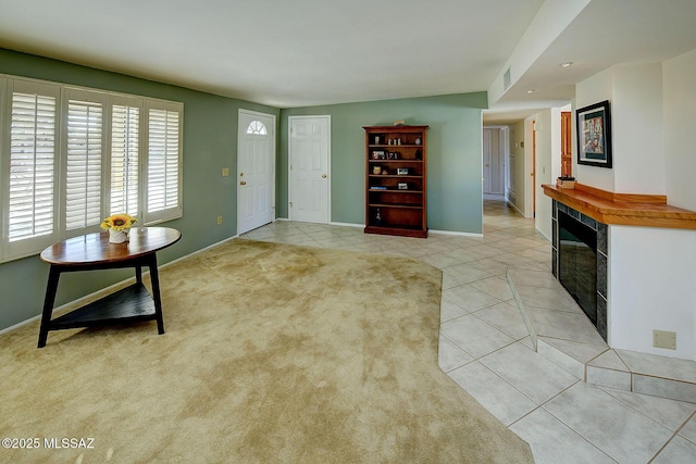 living room featuring a tiled fireplace and light tile patterned floors