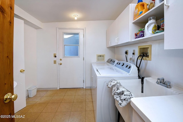 laundry room with washing machine and dryer, cabinets, and light tile patterned flooring