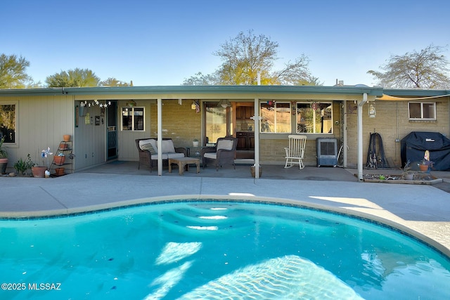 view of pool with a grill and a patio area