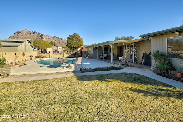 view of pool with a lawn, a patio area, and a mountain view